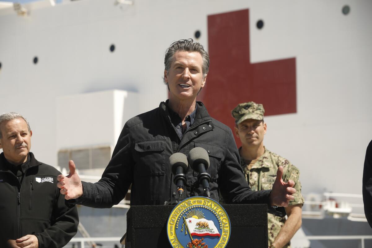 Gov. Gavin Newsom speaks in front of the hospital ship USNS Mercy that arrived into the Port of Los Angeles on Friday.