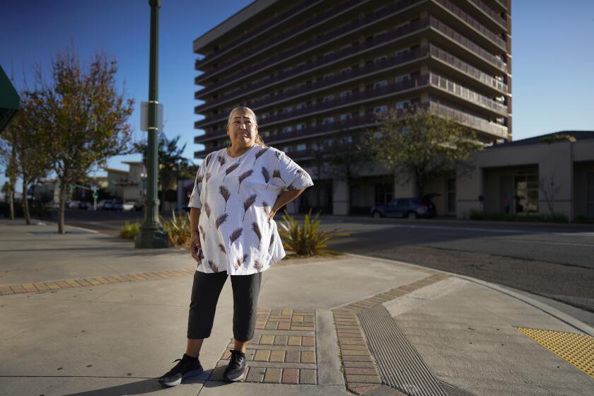 San Diego, CA - April 02: Maria Torres, 52, waits just outside the Ramada Hotel in National City before walking to a local store not far from the hotel. Torres, who lives on Birch Street in Southcrest, is among the flood victims who have been living in the hotel using hotel vouchers. Torres has not received a notice yet but hasn't applied for FEMA. (Nelvin C. Cepeda / The San Diego Union-Tribune)