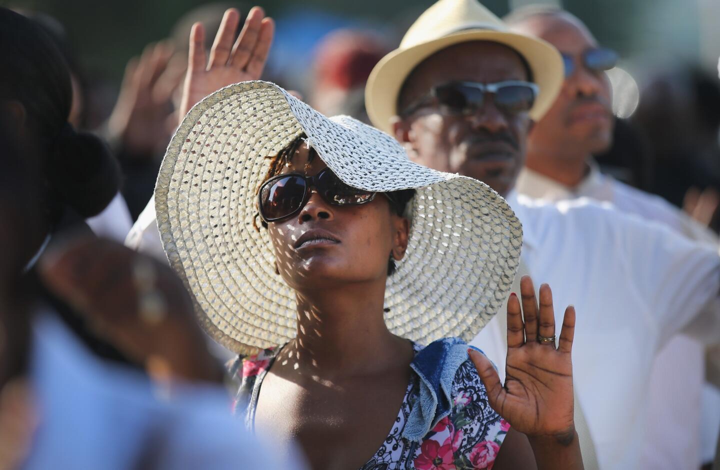 Guests raise their hands as they wait in line to enter the Friendly Temple Missionary Baptist Church for the funeral of Michael Brown.