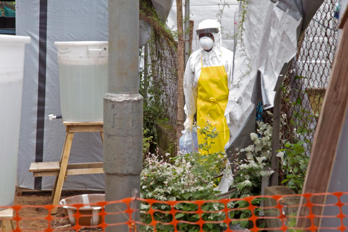 A healthcare worker in protective gear walks near an Ebola isolation unit at the Kenema Government Hospital in Sierra Leone in August. A World Health Organization doctor deployed to the hospital has tested positive for Ebola.