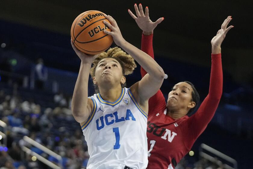 UCLA guard Kiki Rice, left, shoots as Cal State Northridge forward Olivia Smith.