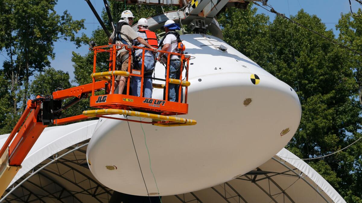 Workers prepare a full-scale replica of NASA's Orion spacecraft for a simulated ocean splashdown test at NASA's Langley Research Center in Hampton, Va.