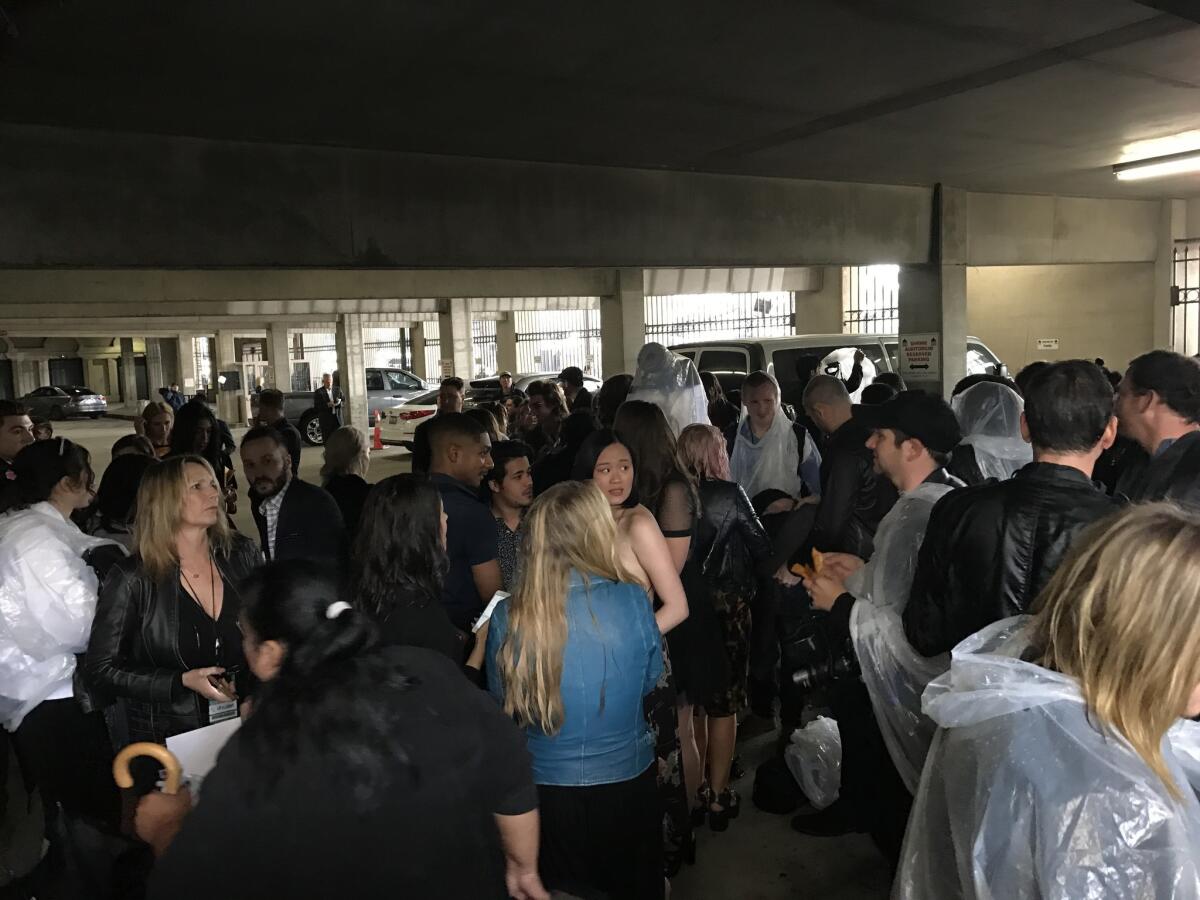 A group of stars and members of the media huddles in a parking deck as a hail storm shuts down the red carpet at the MTV Movie & TV Awards on Sunday afternoon.