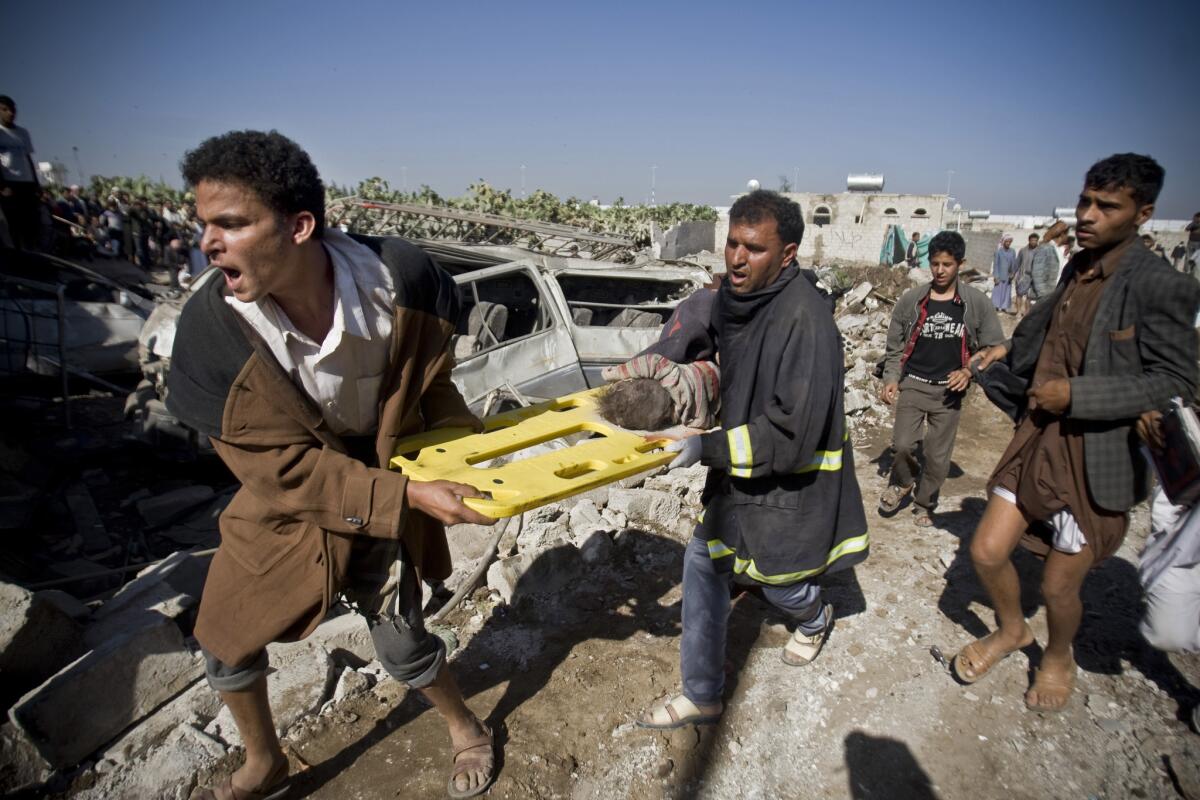 People carry the body of a child they uncovered from under the rubble of houses destroyed by Saudi airstrikes near Sanaa Airport, Yemen on March 25.