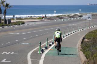 San Diego CA - March 20: A cyclist rides northbound on the east side of South Coast Highway in across from the Cardiff State Beach parking lot in Encinitas on Wednesday, March 20, 2024. Early Sunday, a man died after a crash here where there is a pylon and raised curb separating the bike lane and vehicle lanes. Bicyclists are also allowed to ride in the vehicle lanes. (K.C. Alfred / The San Diego Union-Tribune)