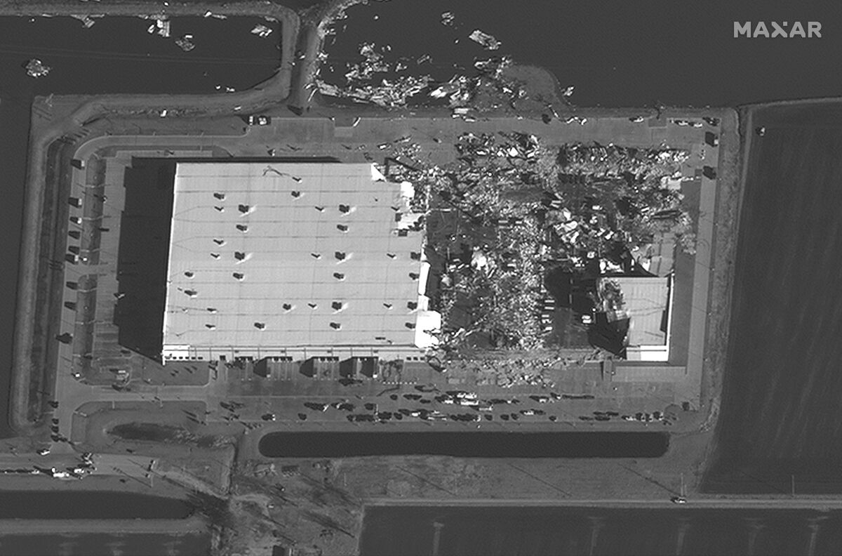 A satellite photo shows a close-up of an Amazon warehouse that is partially destroyed with debris on the ground nearby