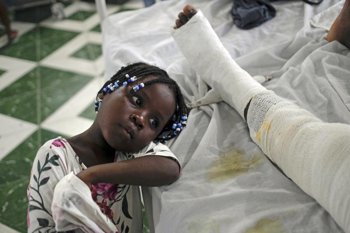 At the hospital in Haiti, a little girl rests next to her mother, who was injured in the earthquake 