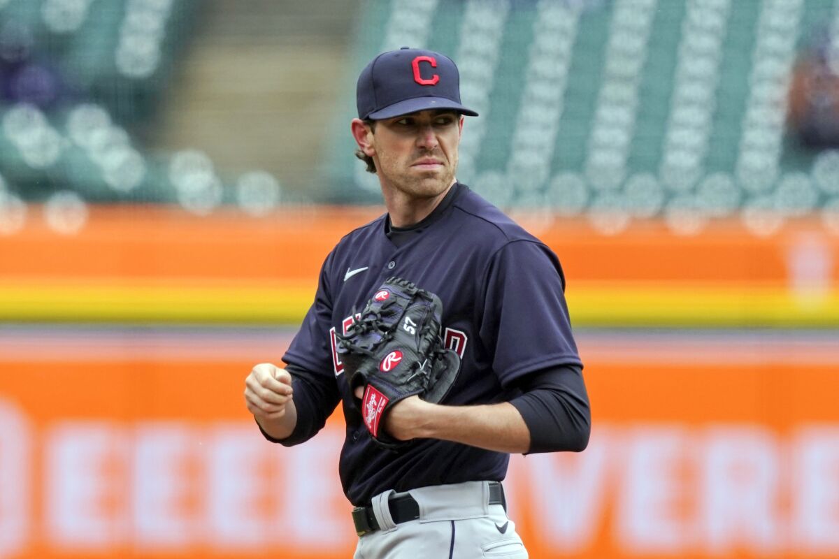 FILE - In this April 1, 2021, file photo, Cleveland Indians starting pitcher Shane Bieber looks towards first during the third inning of a baseball game against the Detroit Tigers, in Detroit. Cleveland's ace and the reigning AL Cy Young winner, who has been out with shoulder inflammation, was encouraged after throwing in the outfield Friday, Aug. 6, 2021, and said he wants to get back on the mound this season. (AP Photo/Carlos Osorio, File)