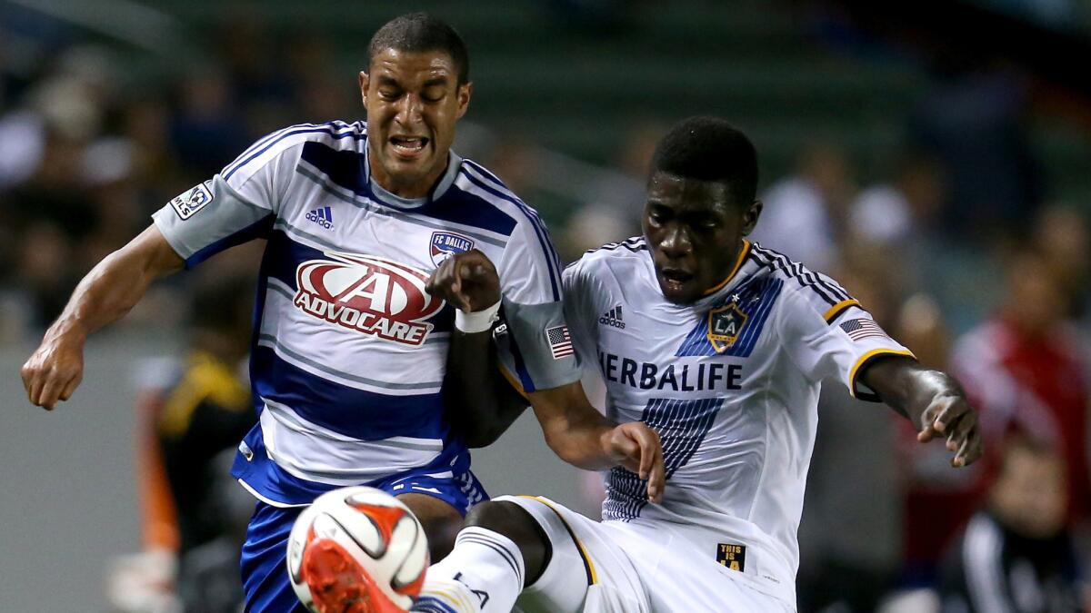 FC Dallas forward Tesho Akindele, left, and Galaxy defender Kofi Opare battle for the ball during the Galaxy's 2-1 win Wednesday night at StubHub Center.