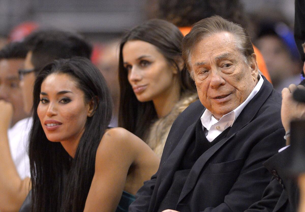 Los Angeles Clippers owner Donald Sterling and V. Stiviano, left, watch the Clippers play the Sacramento Kings.