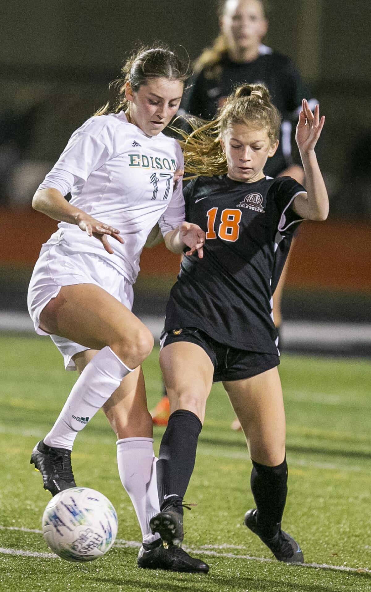 Edison's Rachel Valenzuela and Huntington Beach's Olivia Young battle for a ball during a Surf League match on Tuesday.