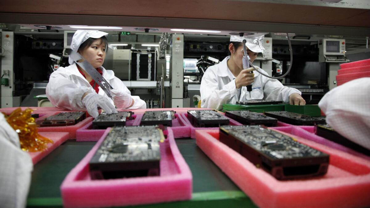 Employees on the assembly line at Hon Hai Group's Foxconn plant in Shenzhen, China. Hon Hai is the parts supplier for Apple and other U.S. tech firms.