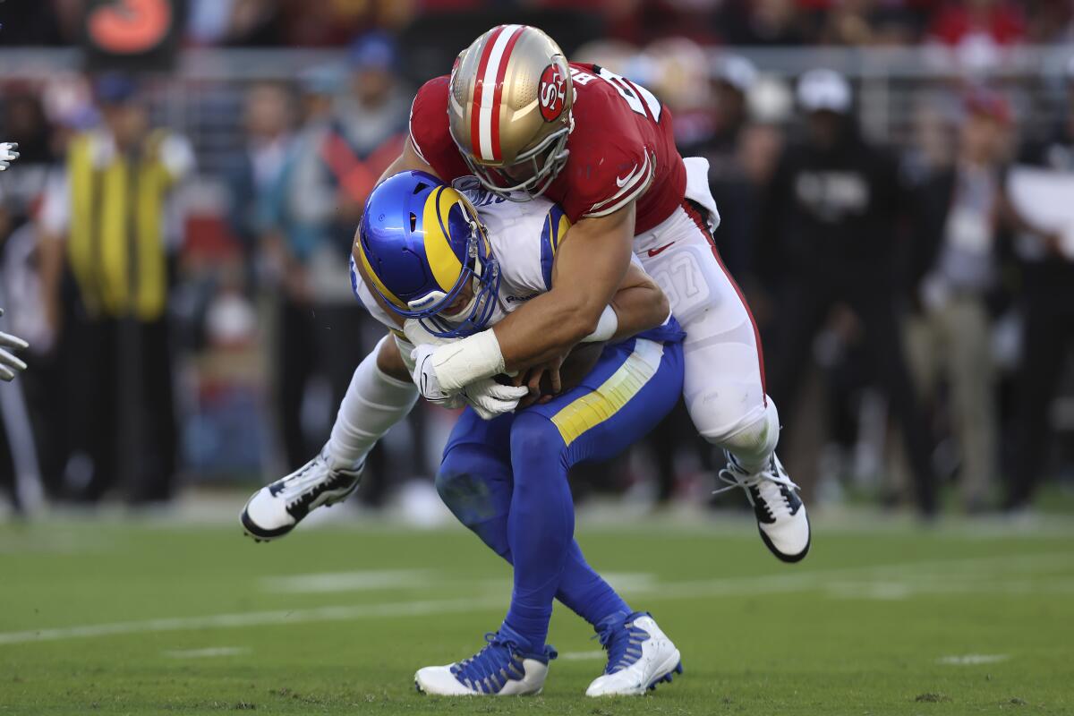 San Francisco 49ers defensive end Nick Bosa, top, sacks Los Angeles Rams quarterback Matthew Stafford 