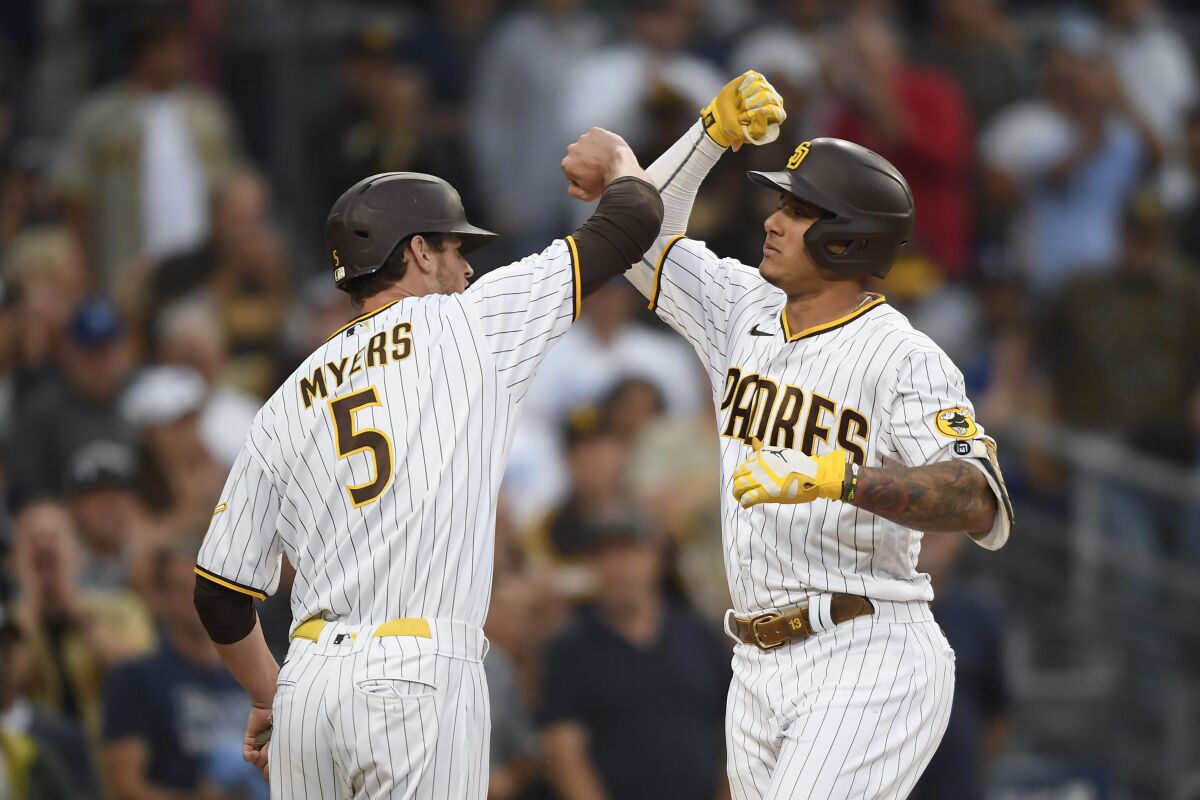 Manny Machado is congratulated by Wil Myers after hitting a three-run home run during the first inning.