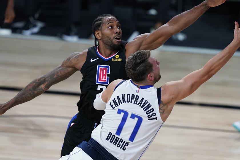 Los Angeles Clippers' Kawhi Leonard (2) fouls Dallas Mavericks' Luka Doncic (77) during the second half.
