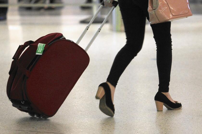 A passenger rolls a bag through Los Angeles International Airport. United Airlines has sent new "sizers" to be installed in terminals to check the size of carry-ons to help weed out oversized ones.