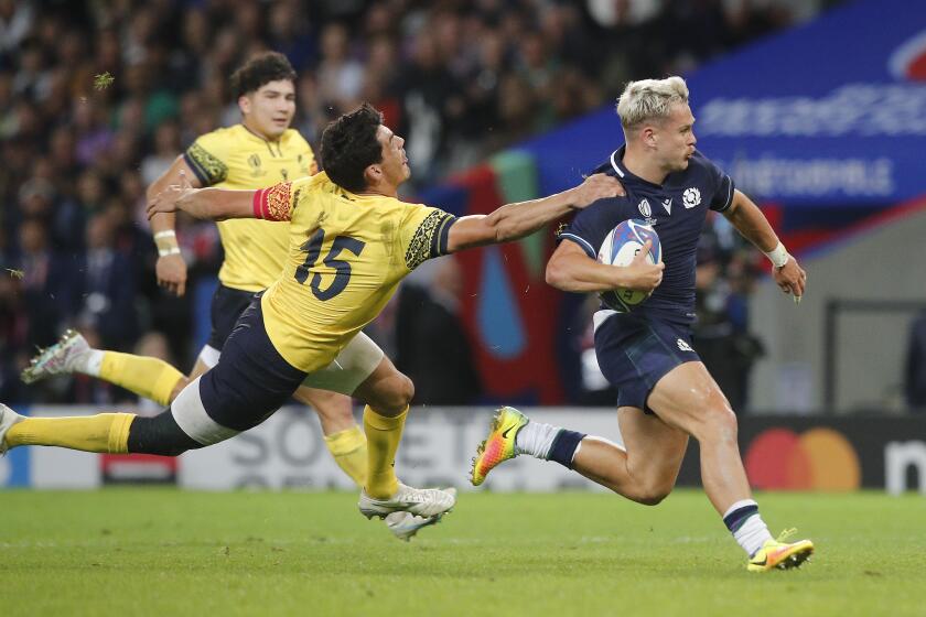 Scotland's Darcy Graham races clear of Romania's Marius Simionescu to scores his side's third try during the Rugby World Cup Pool B match between Scotland and Romania at the Stade Pierre Mauroy in Villeneuve-d'Ascq, outside Lille, France, Saturday, Sept. 30, 2023. (AP Photo/Michel Spingler)