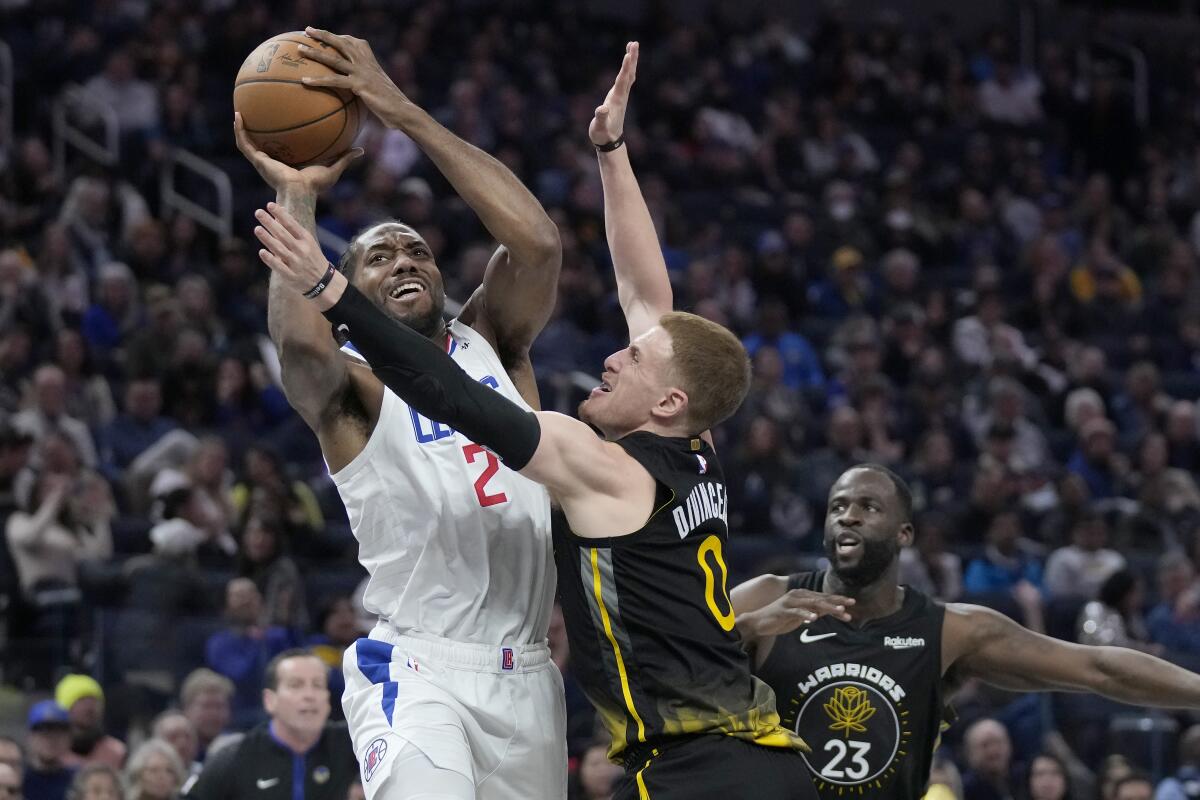 Clippers forward Kawhi Leonard is fouled by Golden State Warriors guard Donte DiVincenzo.