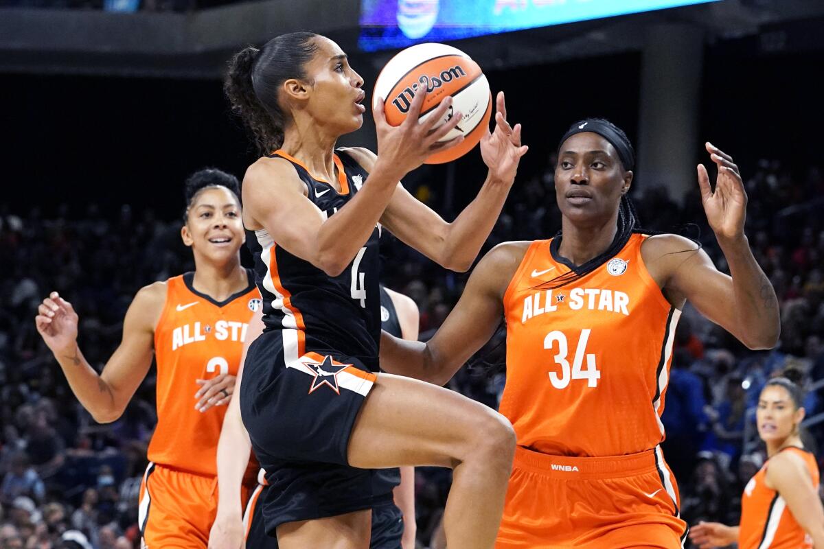 Team Stewart's Skylar Diggins-Smith, center, drives to the basket against Team Wilson's Candace Parker, left, and Sylvia Fowles during the first half of a WNBA All-Star basketball game in Chicago, Sunday, July 10, 2022. (AP Photo/Nam Y. Huh)