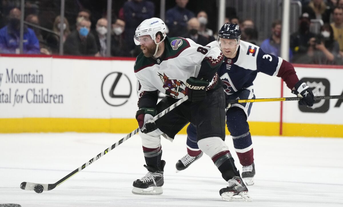 Arizona Coyotes right wing Phil Kessel, front, collects the puck with Colorado Avalanche defenseman Jack Johnson in pursuit in the second period of an NHL hockey game Tuesday, Feb. 1, 2022, in Denver. (AP Photo/David Zalubowski)