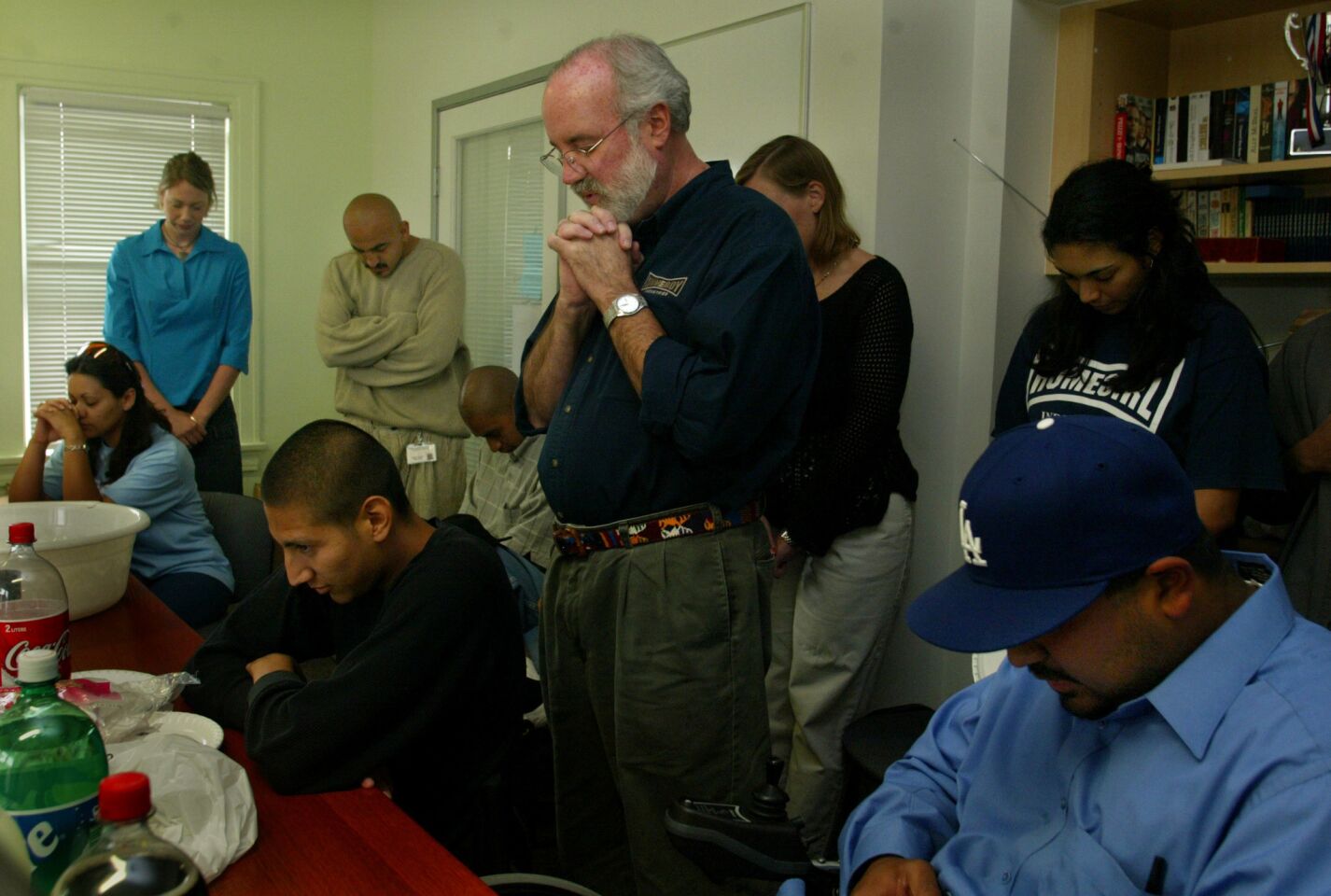Father Gregory Boyle says a prayer during a birthday party for Luis A. Moreno at Homeboy Industries in June 2003.