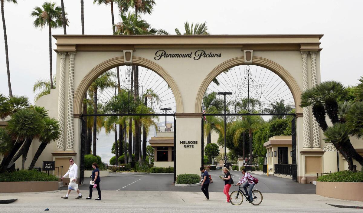 People pass the main gate to Paramount Pictures on Melrose Avenue in Los Angeles.