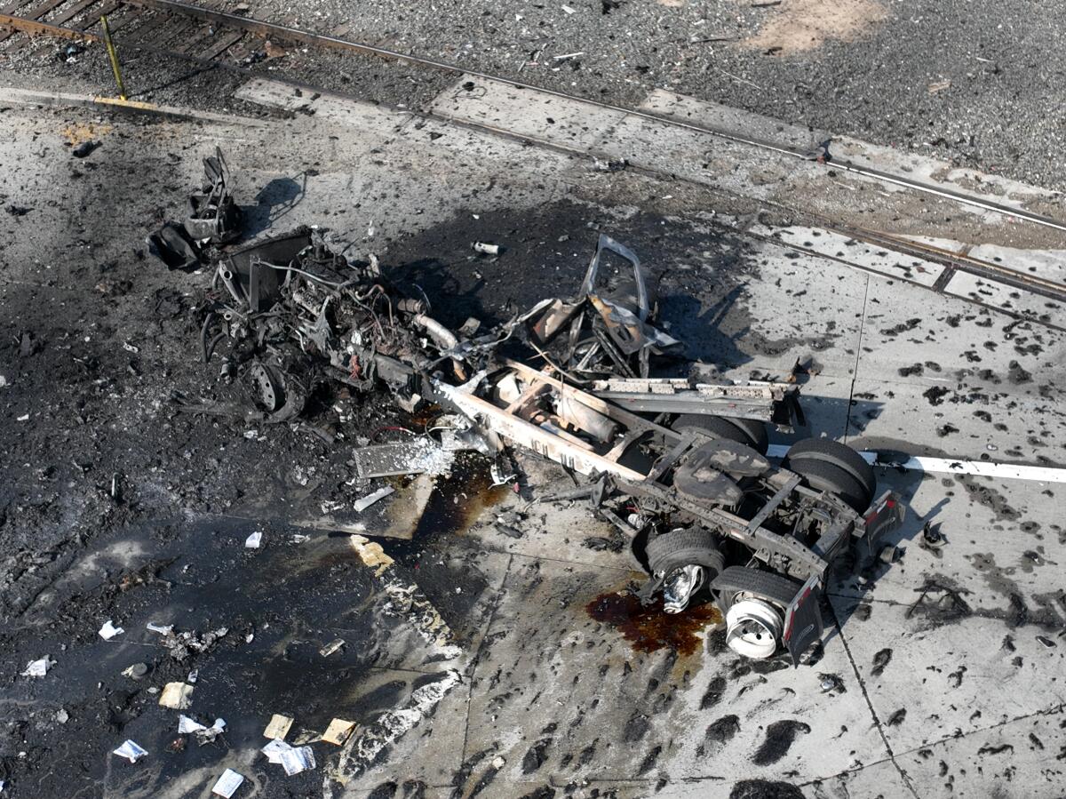 Aerial view of truck explosion, with firefighting equipment visible in the debris.