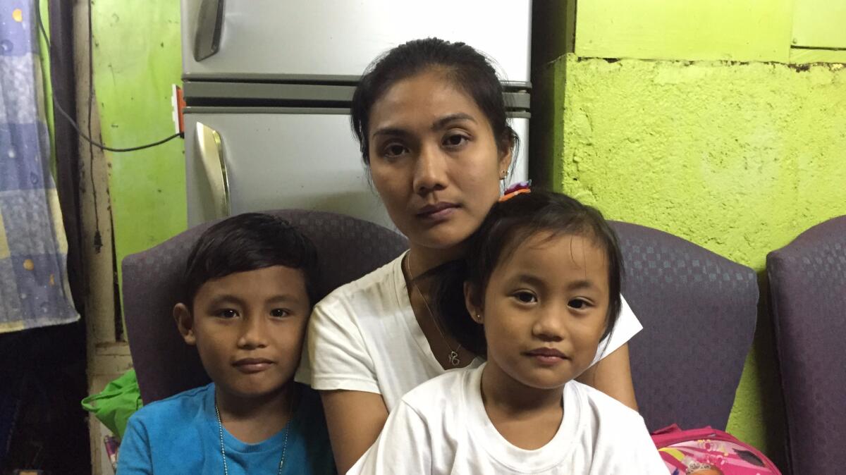 Sheila Rivera, 31, with her two children at their home in San Mateo, outside Manila. Rivera's husband, Letlet Belmonte, 31, was killed by police on June 20.