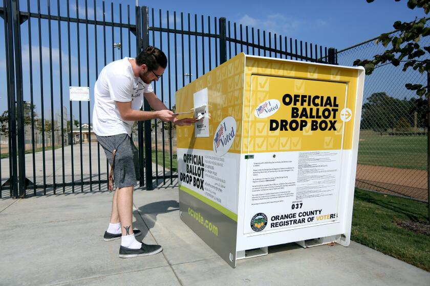Hayden Wyndhamsmith, 23 of Tustin, was visiting friends when he decided to drop off his ballot at a nearby official ballot box located at the TeWinkle Park Athletic Complex, in Costa Mesa on Wednesday, Oct. 21, 2020.