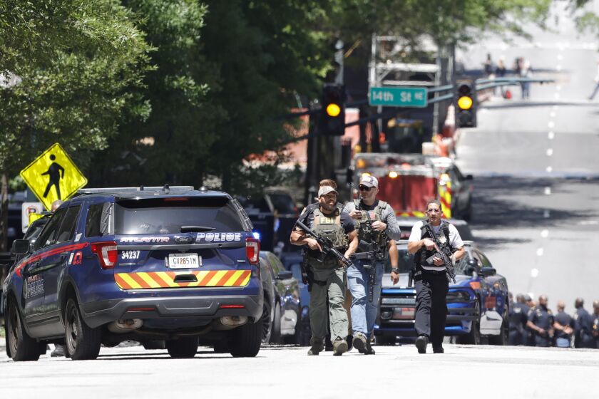 Law enforcement officers arrive near the scene of an active shooter on Wednesday, May 3, 2023 in Atlanta. Atlanta police said there had been no additional shots fired since the initial shooting unfolded inside a building in a commercial area with many office towers and high-rise apartments. (AP Photo/Alex Slitz)