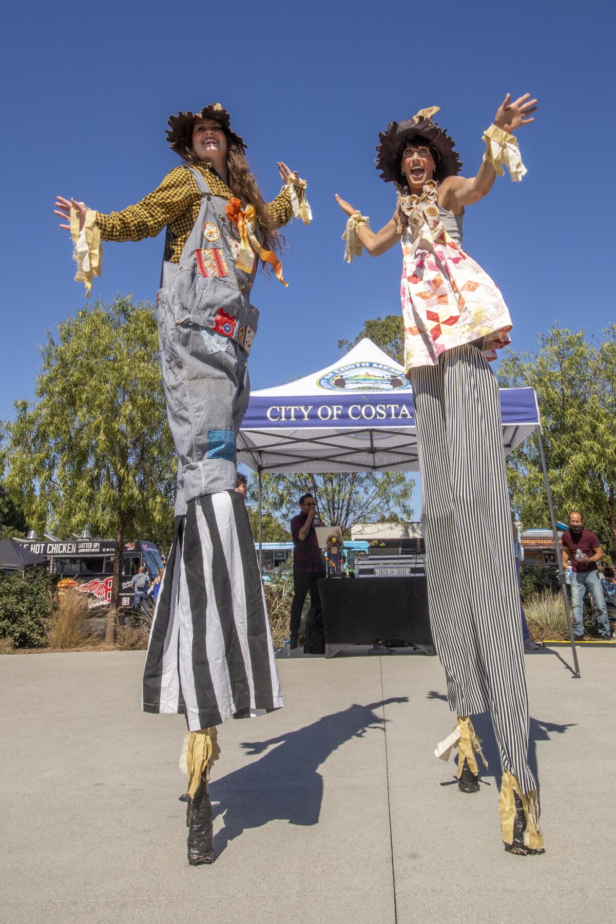 Stilt walkers Morgan and Joy Halverson of Mission Viejo's Circus Joy dance at the 2021 Scarecrow Festival in Costa Mesa.