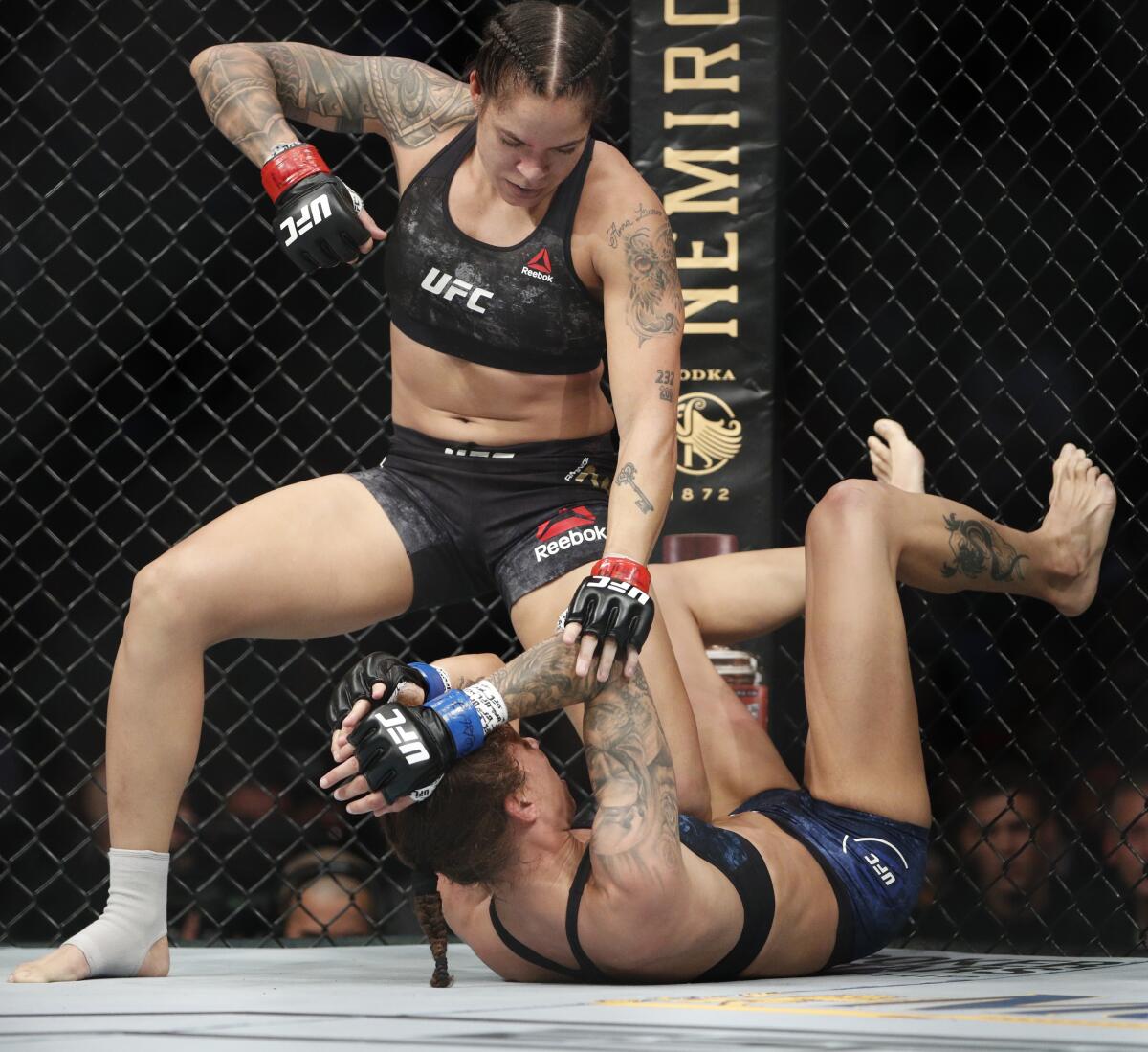 Amanda Nunes, top, fights Germaine de Randamie in a mixed martial arts women's bantamweight championship bout at UFC 245, Saturday, Dec. 14, 2019, in Las Vegas. (AP Photo/John Locher)