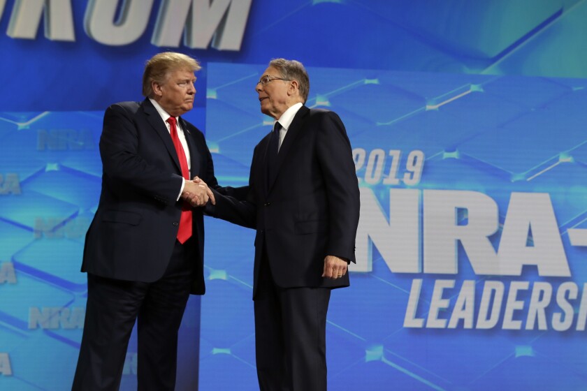 El presidente estadounidense Donald Trump estrecha la mano del director general de la Asociación Nacional del Rifle