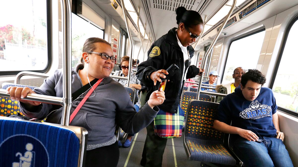 A Los Angeles County Sheriff's Department employee checks commuters' fares on an Expo Line train from Santa Monica to Los Angeles.