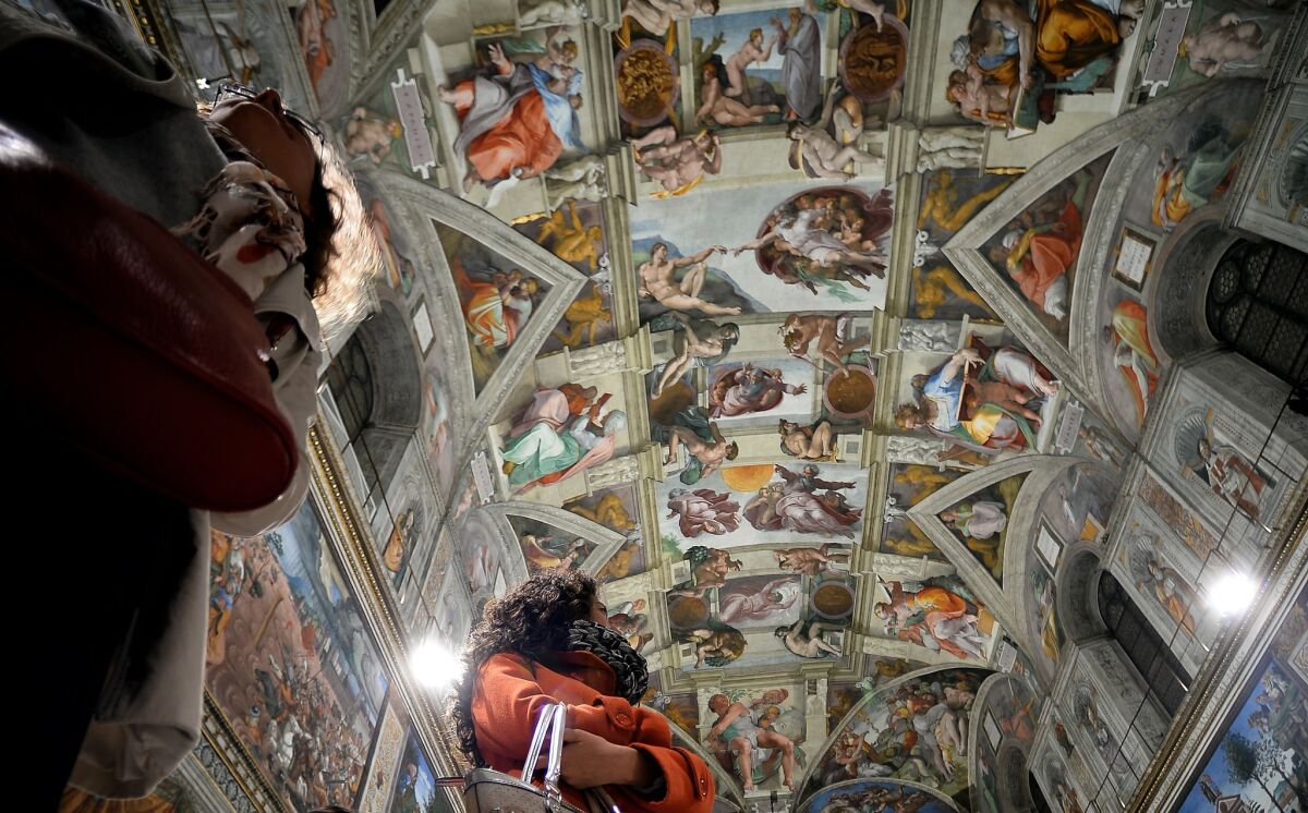 Journalists stare at the Sistine Chapel with its new lighting during a press visit at the Vatican on Wednesday.