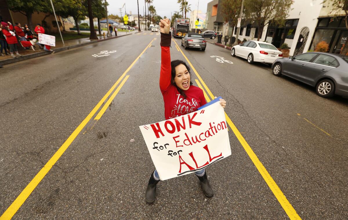 Westminster Elementary School kindergarten teacher Beth Clark stands in the middle of Abbot Kinney Boulevard in Venice imploring passing drivers to honk.