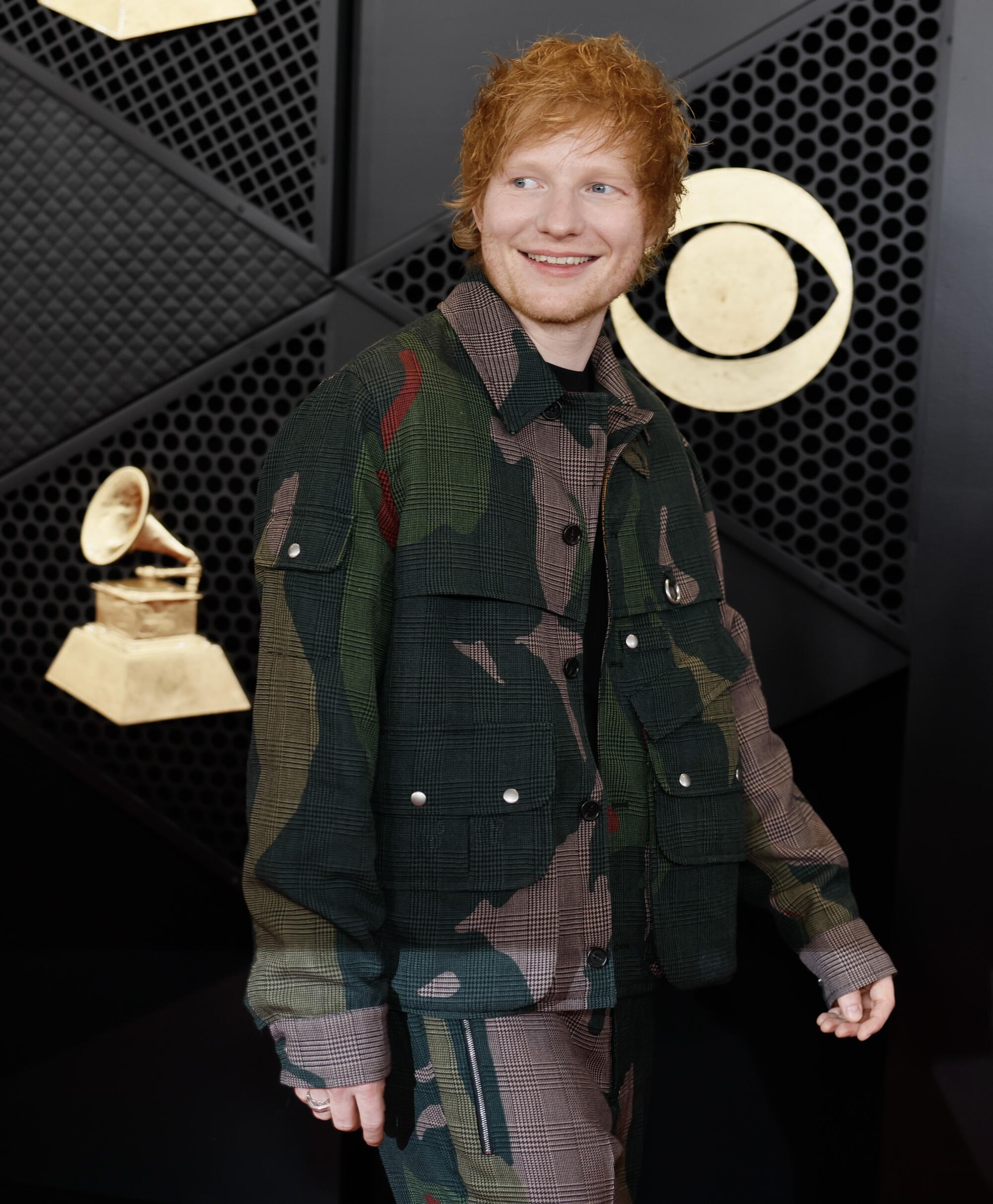 Ed Sheeran wears a camo jacket and pants 