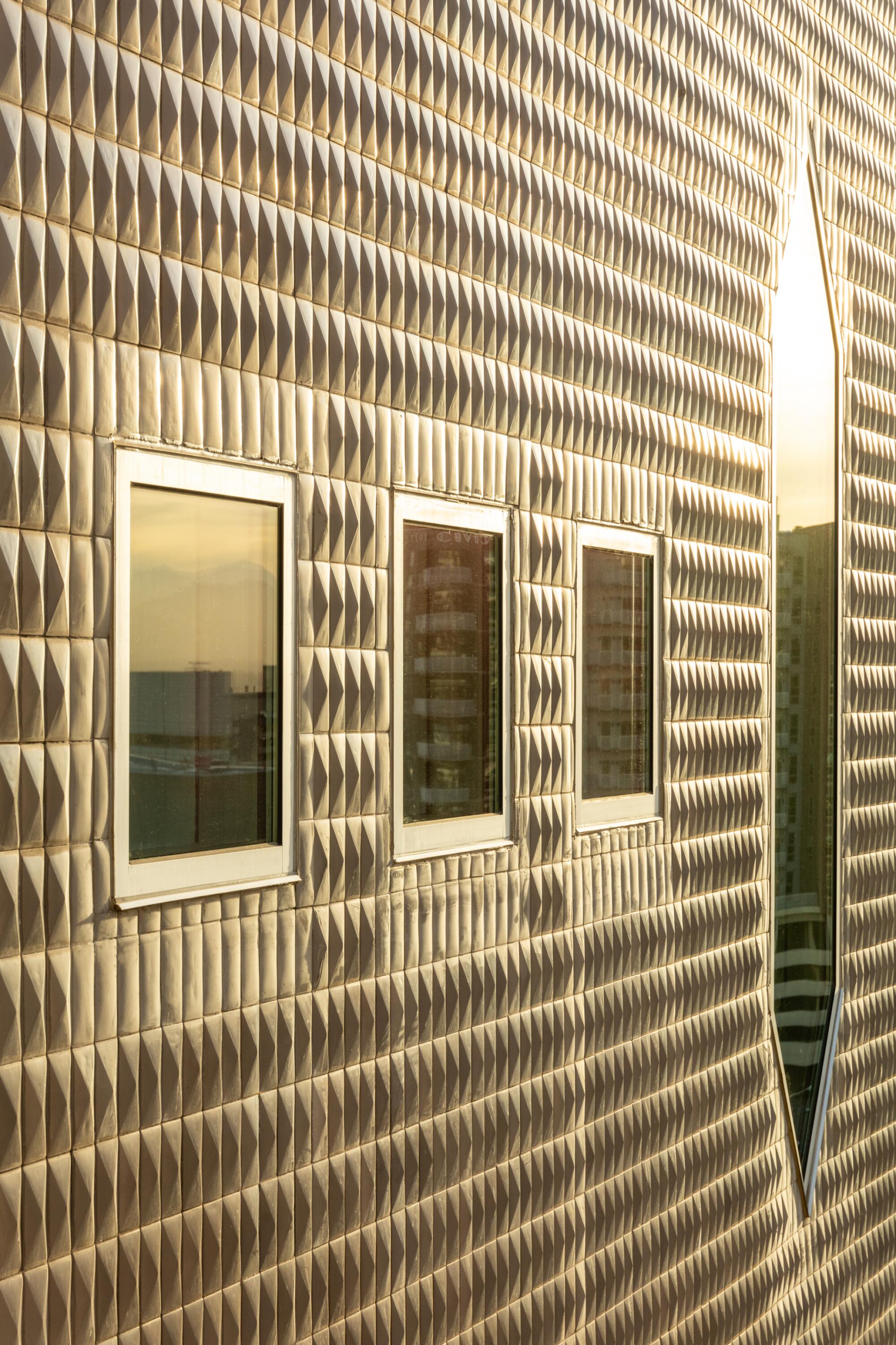 Sunlight reflects on the ceramic tiled facade of the Denver Art Museum by Gio Ponti, making it look golden.
