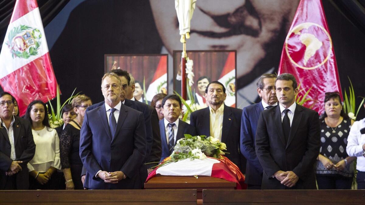 Jorge Munoz, left, the mayor of Lima, Peru, and Venezuelan Ambassador Carlos Scull, right, attend a wake for former Peruvian President Alan Garcia in Lima on Thursday.