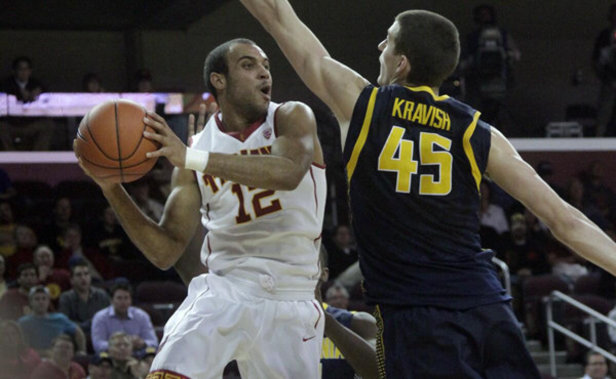 USC's Julian Jacobs, left, looks to pass around California's David Kravish during the second half of the Trojans' 77-69 upset win Wednesday night at the Galen Center.