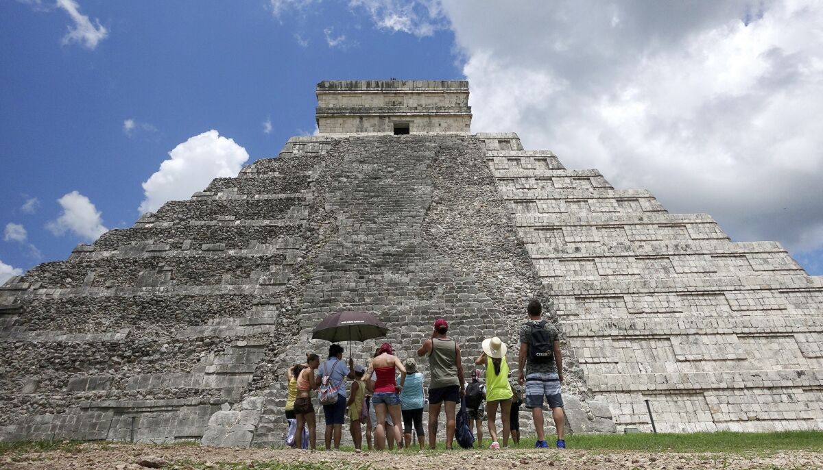 Tourists are dwarfed by El Castillo at the Chichen Itza ruins in Yucatan, Mexico.