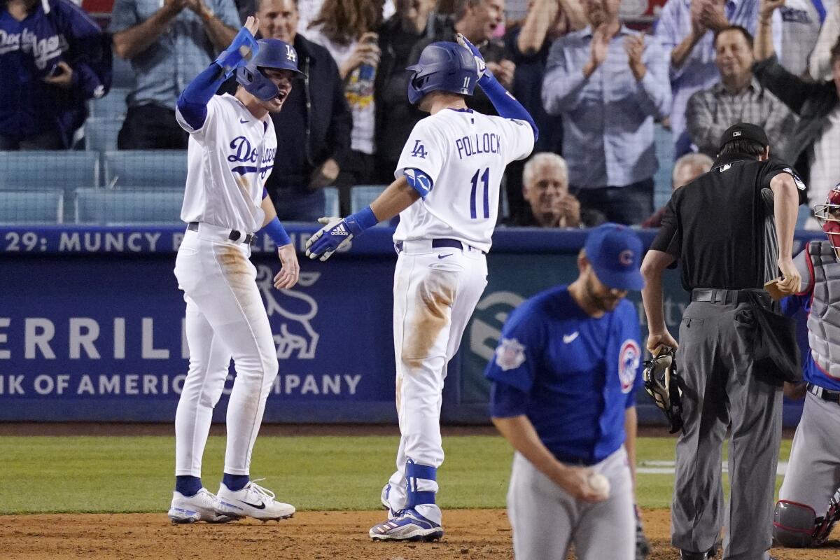 AJ Pollock, second from left, is congratulated by Dodgers teammate Gavin Lux after hitting a tie-breaking, two-run home run.