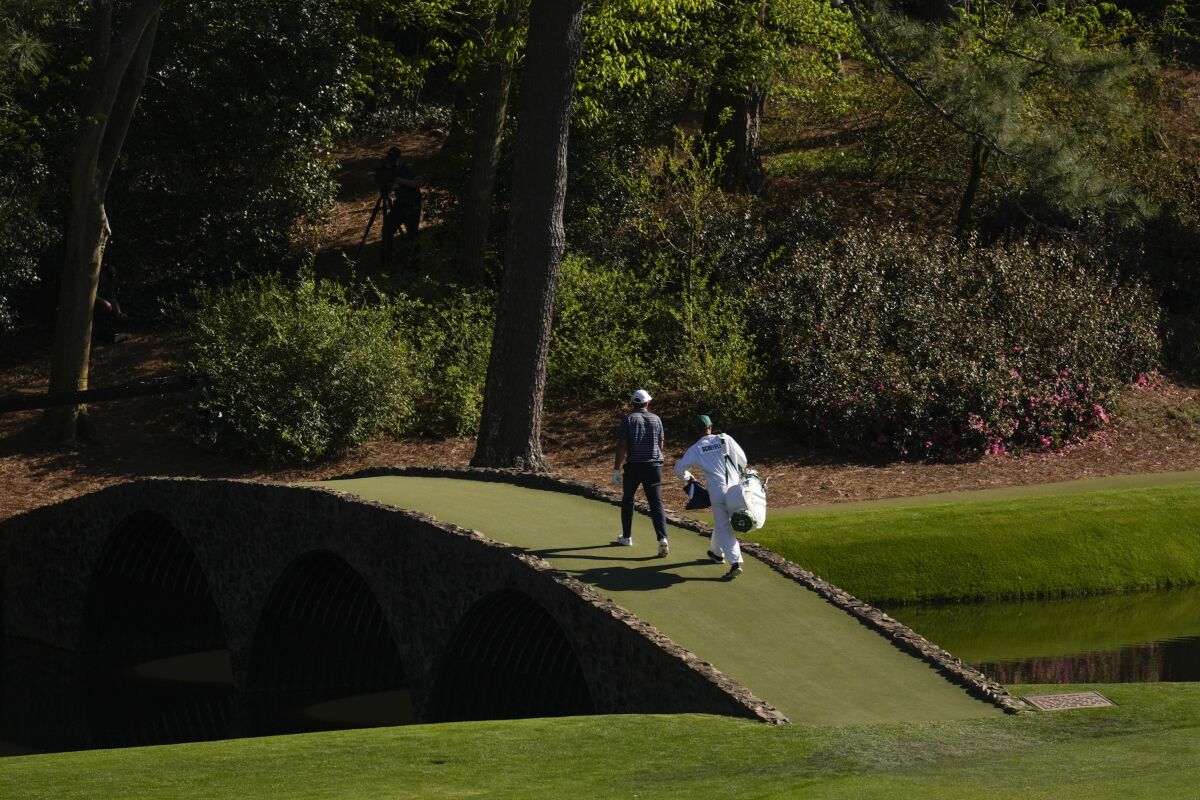 Scottie Scheffler walks across the Ben Hogan Bridge at the 12th hole during the final round at the Masters golf tournament on Sunday, April 10, 2022, in Augusta, Ga. (AP Photo/Jae C. Hong)