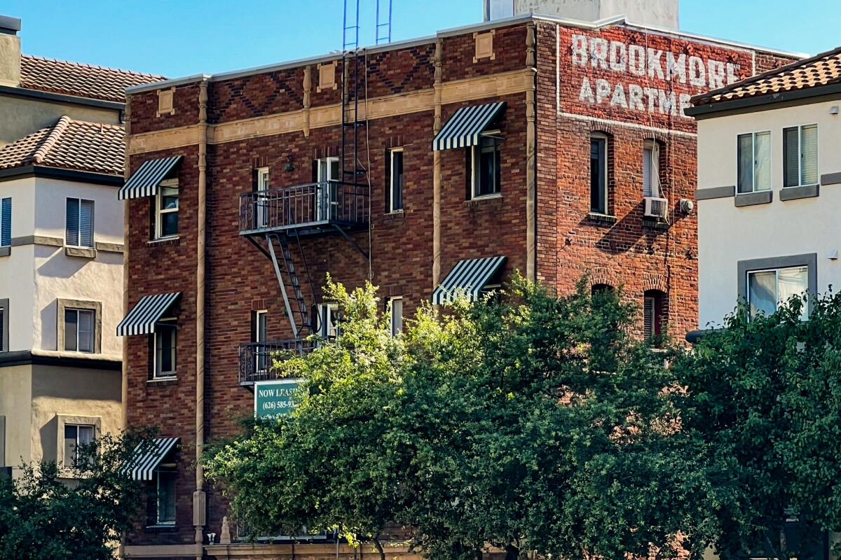 A multistory brick building reads "Brookmore Apartments" on its side.