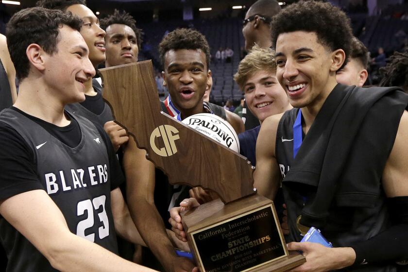 Sierra Canyon's Jacob Miller, left, and Scotty Pippen Jr. right, hold the championship trophy they received after the team defeated Sheldon 76-52 in the CIF boys' open Division state high school basketball championship game Saturday, March 9, 2019, in Sacramento, Calif. (AP Photo/Rich Pedroncelli)