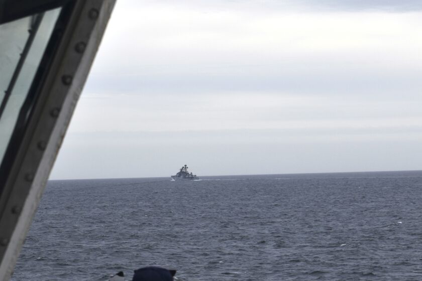 In this photo provided by the U.S. Coast Guard, a Coast Guard Cutter Kimball crew-member observes a foreign vessel in the Bering Sea, Monday, Sept. 19, 2022. The U.S. Coast Guard cutter on routine patrol in the Bering Sea came across the guided missile cruiser from the People's Republic of China, officials said Monday, Sept. 26. (U.S. Coast Guard District 17 via AP)