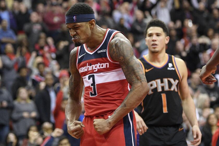 Washington Wizards guard Bradley Beal (3) reacts after he made a basket during triple overtime of an NBA basketball game next to Phoenix Suns guard Devin Booker (1), Saturday, Dec. 22, 2018, in Washington. (AP Photo/Nick Wass)