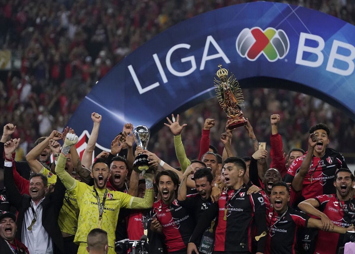 Atlas FC players lift the trophy after winning the Liga MX Apertura final against León.