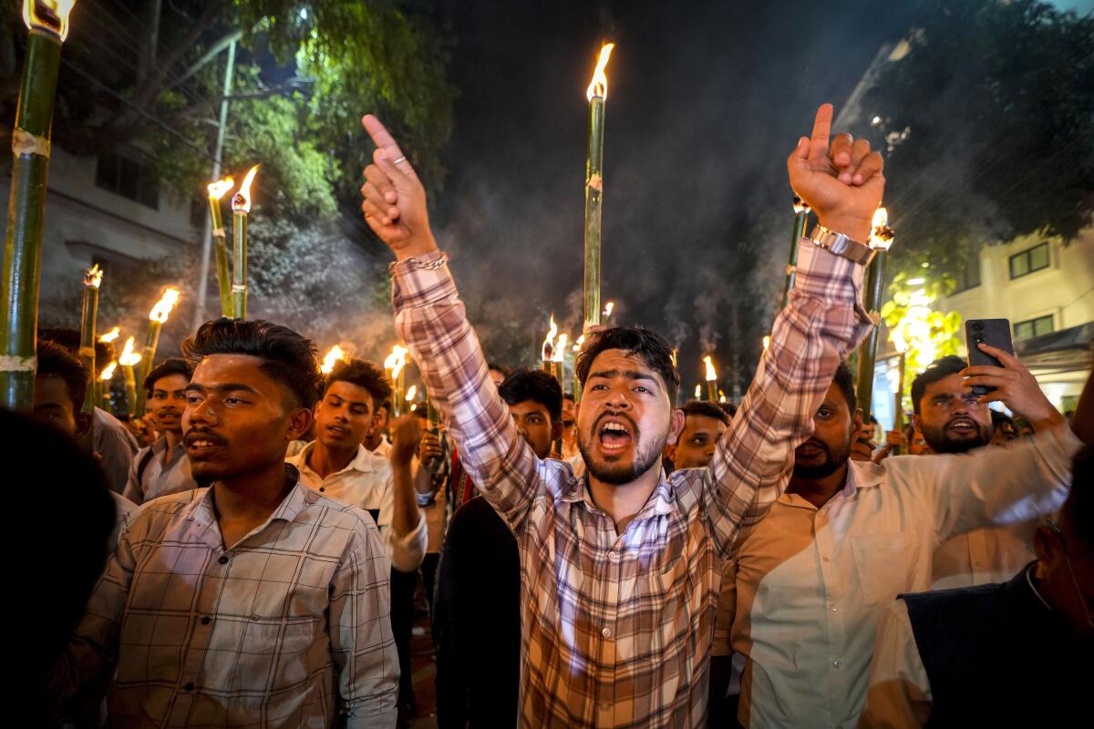 Protesters hold tall torches in a march in India.