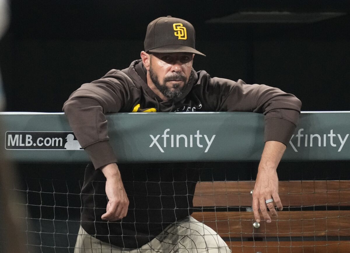 Former Padres manager Jayce Tingler leans over the dugout rail during August game at Coors Field.
